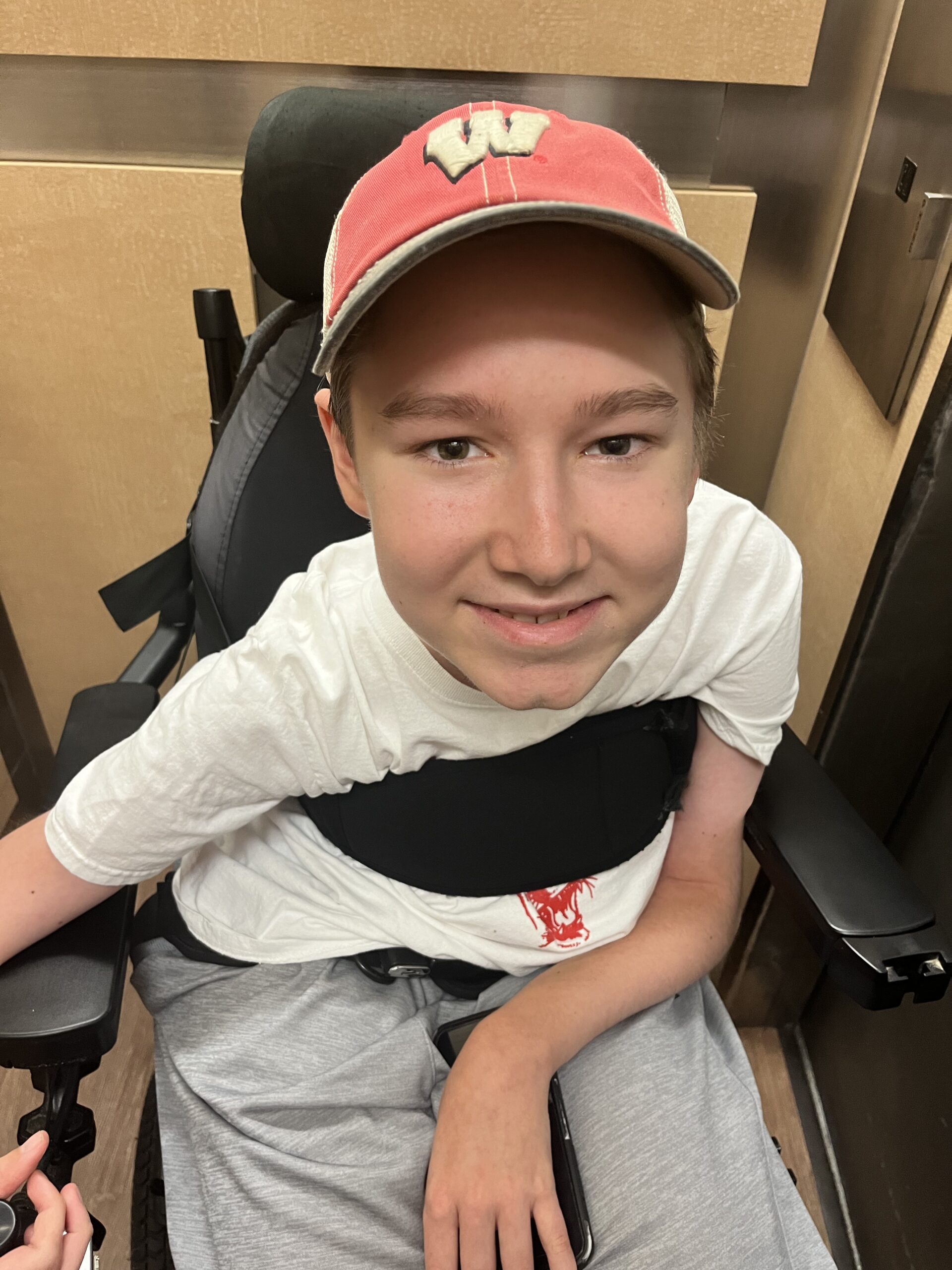 TJ smiling in his power wheelchair