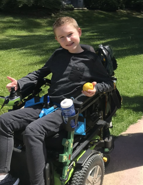 TJ smiling in his wheelchair